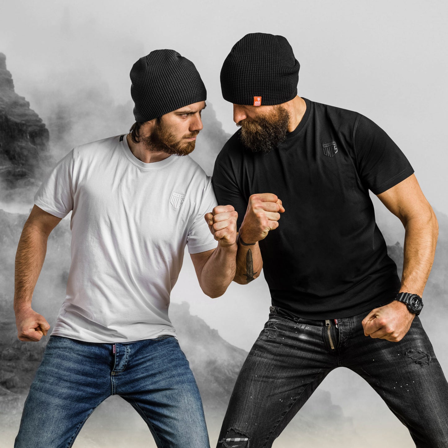 Dva muži v elastanových tričkách UNCS, černém a bílém, minimalistický design.