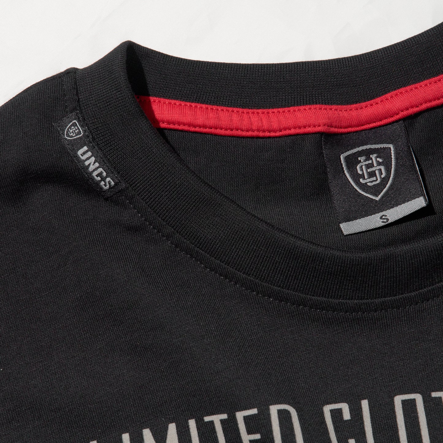 Pánské černé oversize tričko UNCS s červeno-stříbrným designovým potiskem.