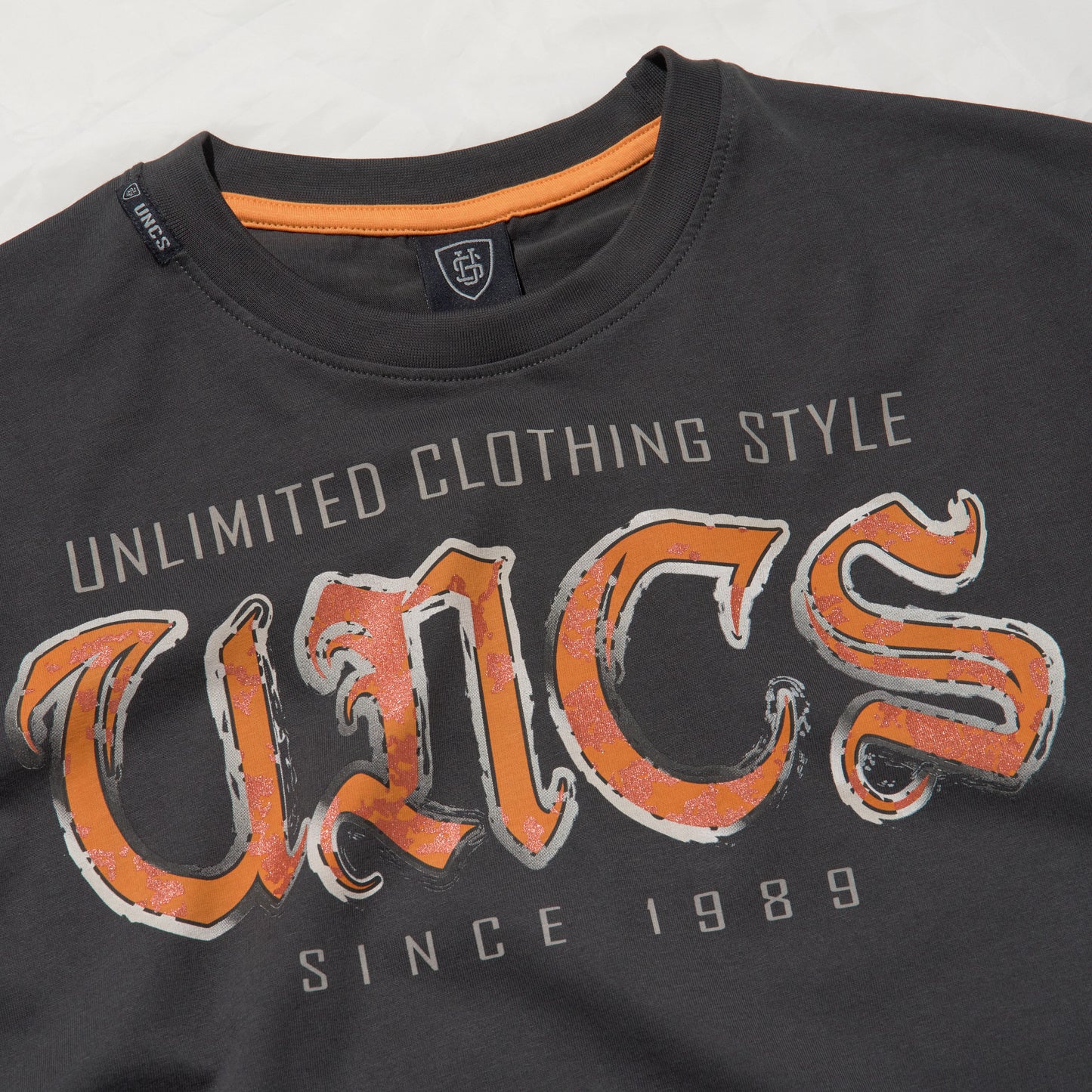Pánské tmavě šedé oversize triko UNCS s oranžovo-stříbrným designovým potiskem